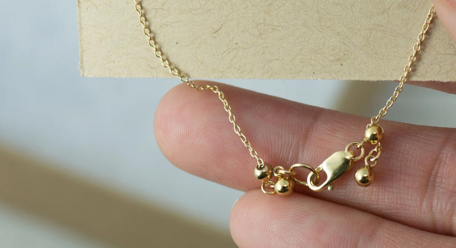 14k gold-filled chain and clasp between fingertips