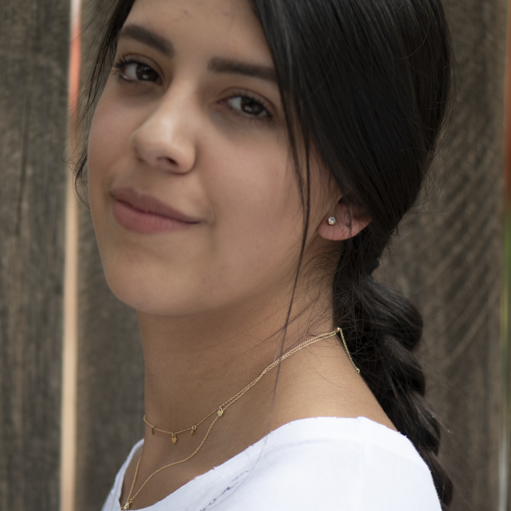 Iris CZ stud earring worn with dainty gold necklaces, side view