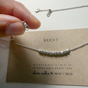 Lobster clasp and adjustable chain above the Extra Bold sterling silver Morse code necklace on its card
