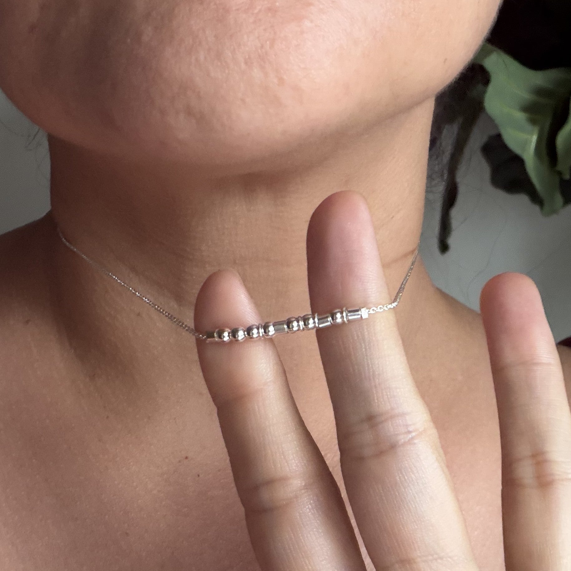 Sterling silver Morse code necklace with our largest beads, shown against fingers for size