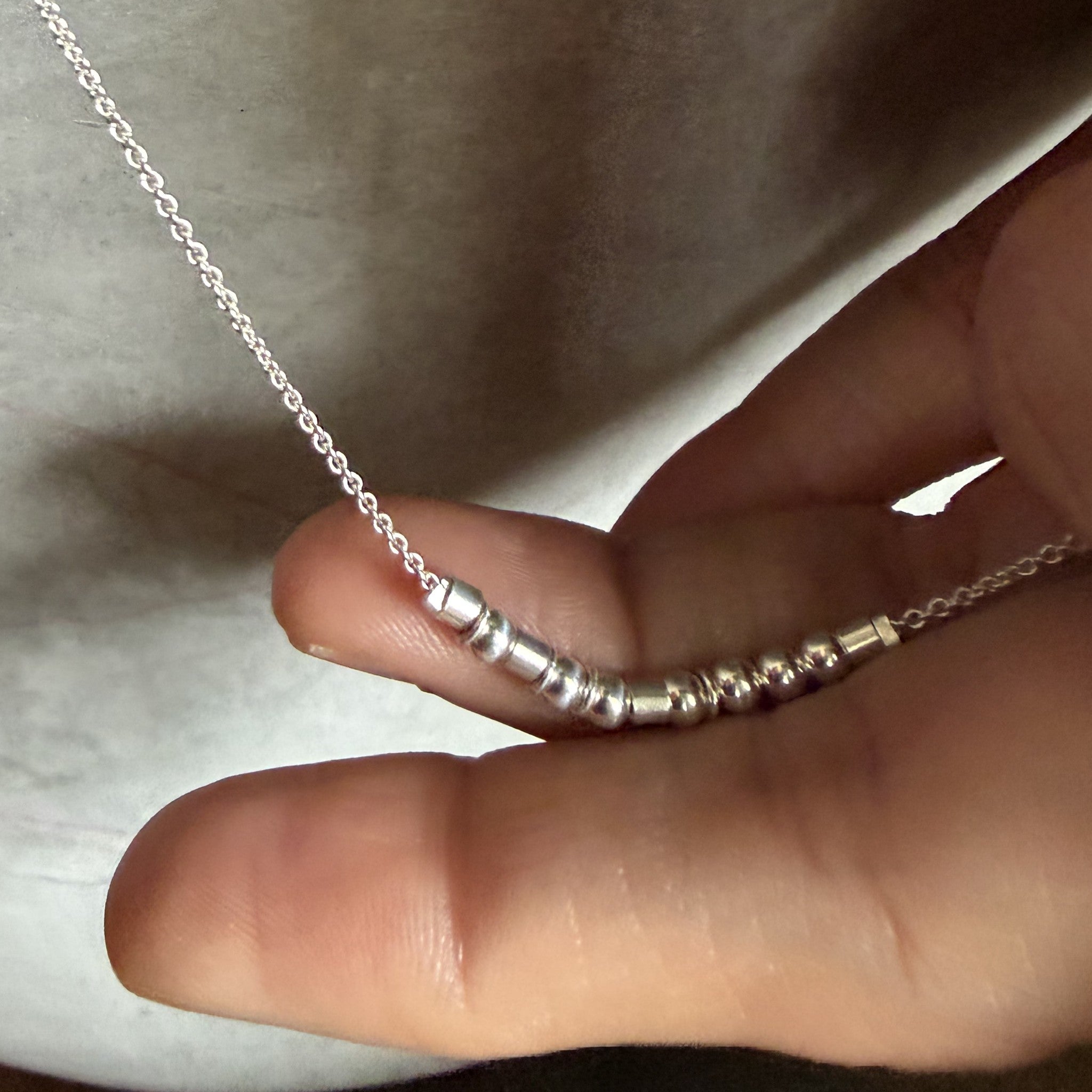 Close-up of the sterling silver Morse code beads and chain