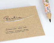 Dainty Silver Bestie Morse Code Bracelet with Tiny Silver Spacers Separating Each Letter. On Custom Printed Bestie Card Showing Morse Code.