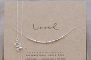 Dainty Silver Chain Loved Morse Code Necklace on a Brown Kraft Card Sowing Morse Code Dots and Dashes Matching the Delicate Chain