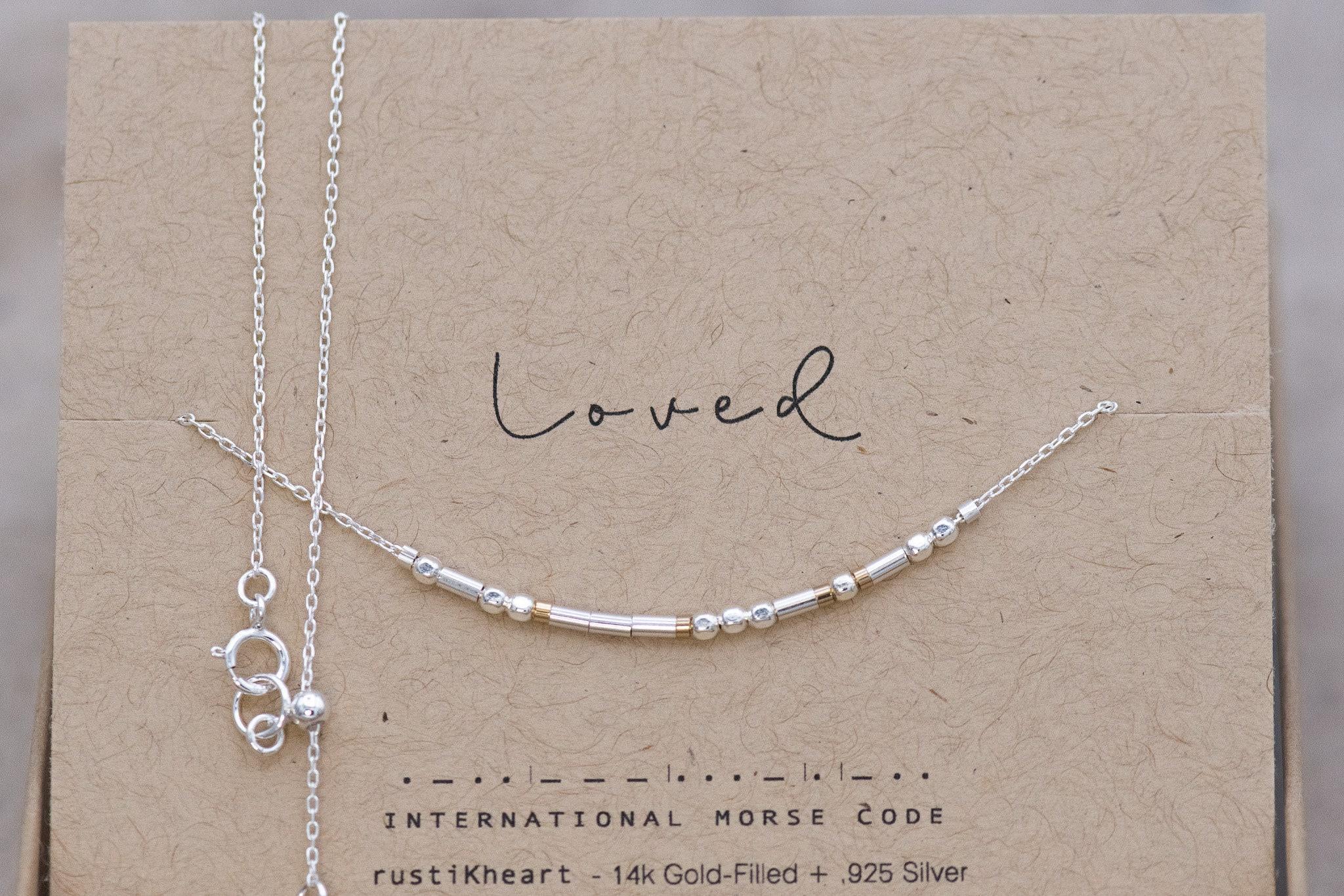Dainty Silver Chain Loved Morse Code Necklace on a Brown Kraft Card Sowing Morse Code Dots and Dashes Matching the Delicate Chain