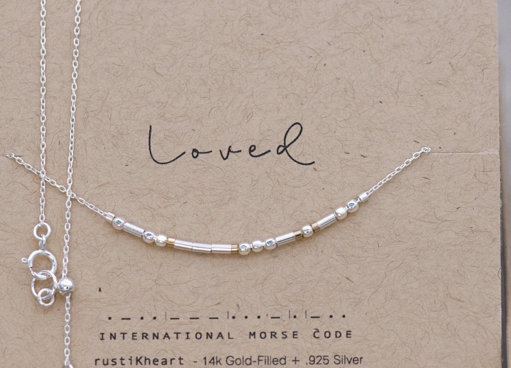 Dainty Silver Chain Loved Morse Code Necklace on a Brown Kraft Card Sowing Morse Code Dots and Dashes Matching the Delicate Chain
