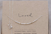 Dainty Silver Chain Loved Morse Code Necklace on a Brown Kraft Card Sowing Morse Code Dots and Dashes Matching the Delicate Chain
