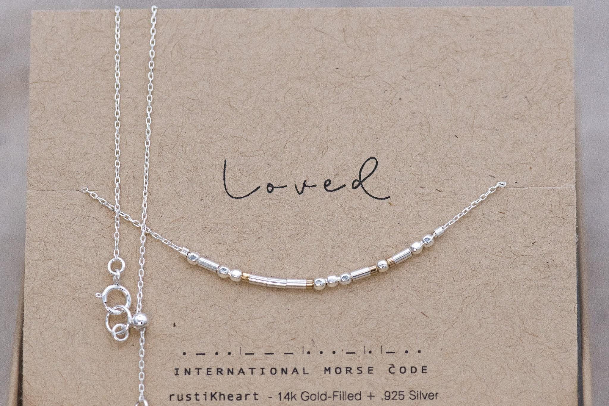 Dainty Silver Chain Loved Morse Code Necklace on a Brown Kraft Card Sowing Morse Code Dots and Dashes Matching the Delicate Chain